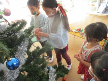 クリスマスツリーに飾りつけをする子どもたち。